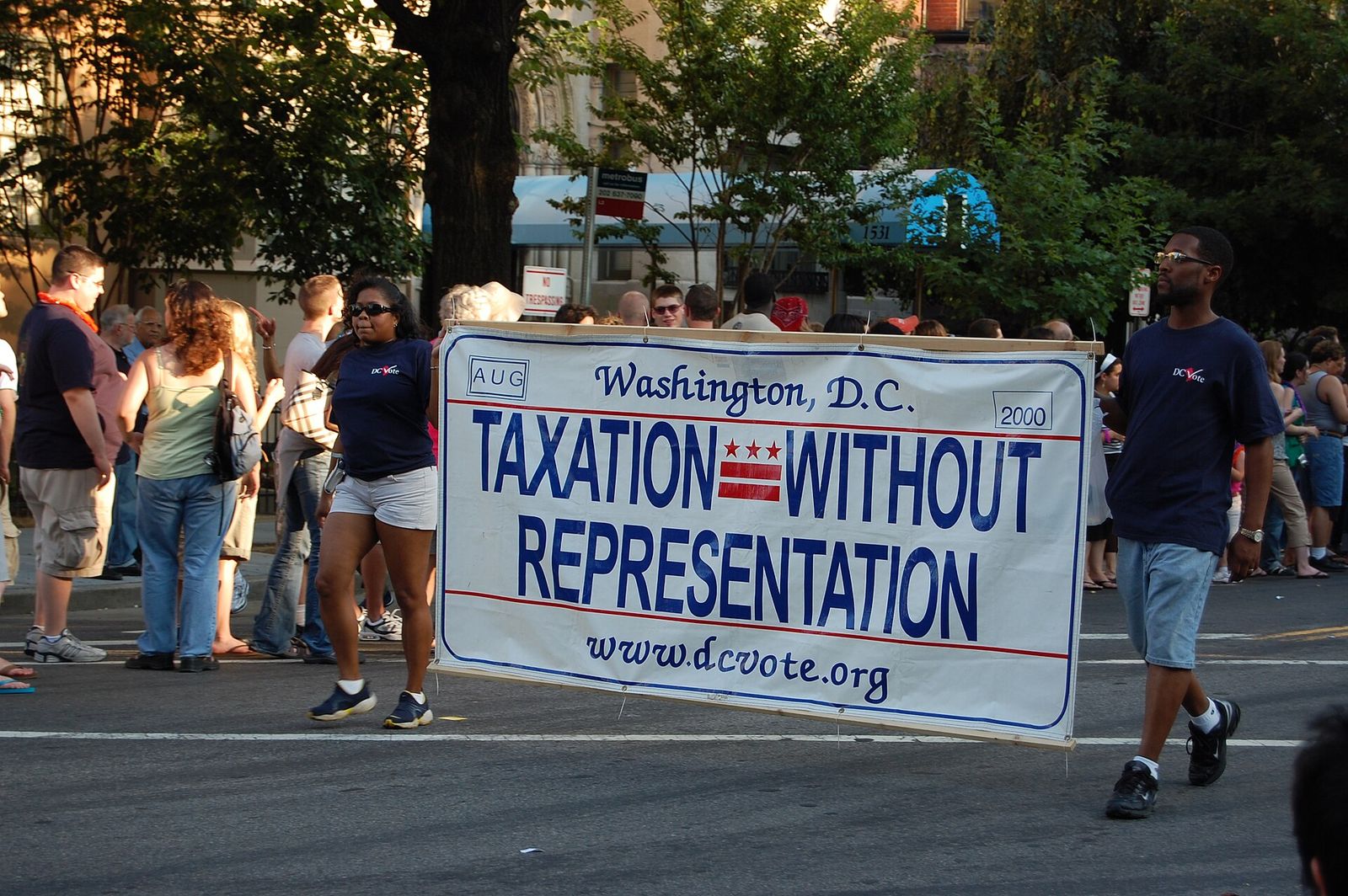 Marchers in Washington, DC carry a banner reading Taxation Without Representation.