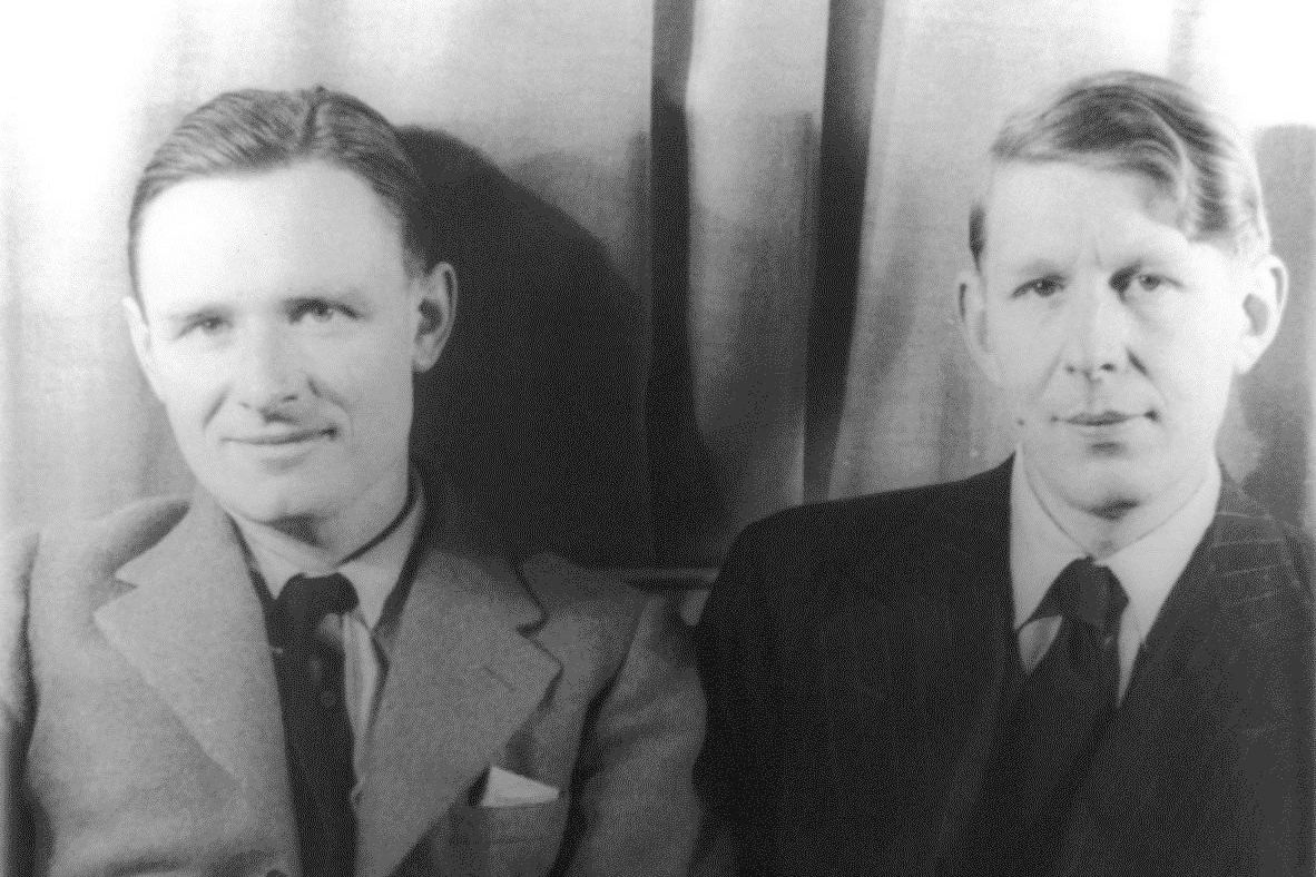 Christopher Isherwood and W. H. Auden standing side by side in suits.