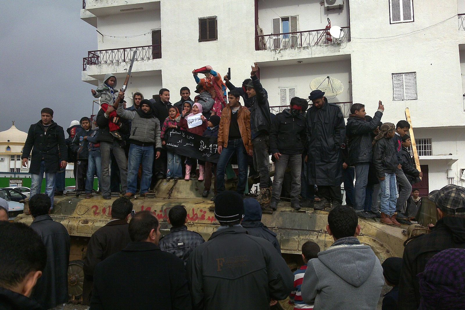 Libyans, including children, standing on a captured tank in Al Bayda.